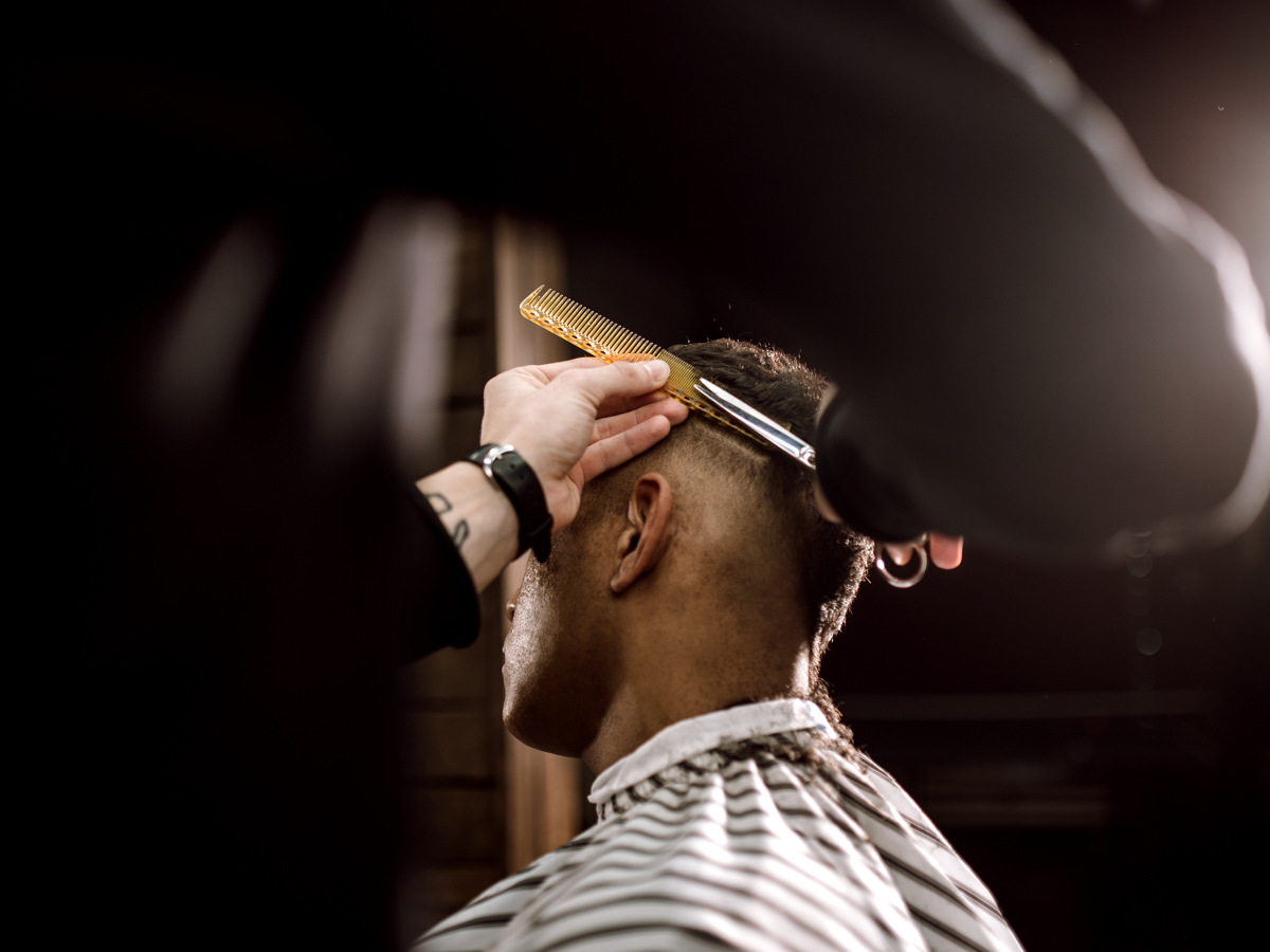 En man får sitt hår fixat. 