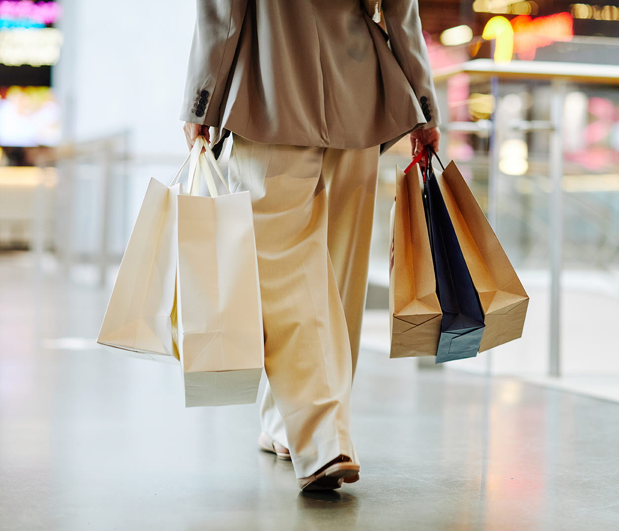 En tjej som bär på shoppingpåsar i en galleria. 