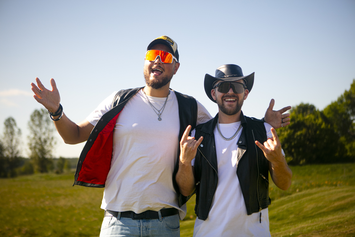 Två män med skinnvästar, solglasögon och keps och hatt.