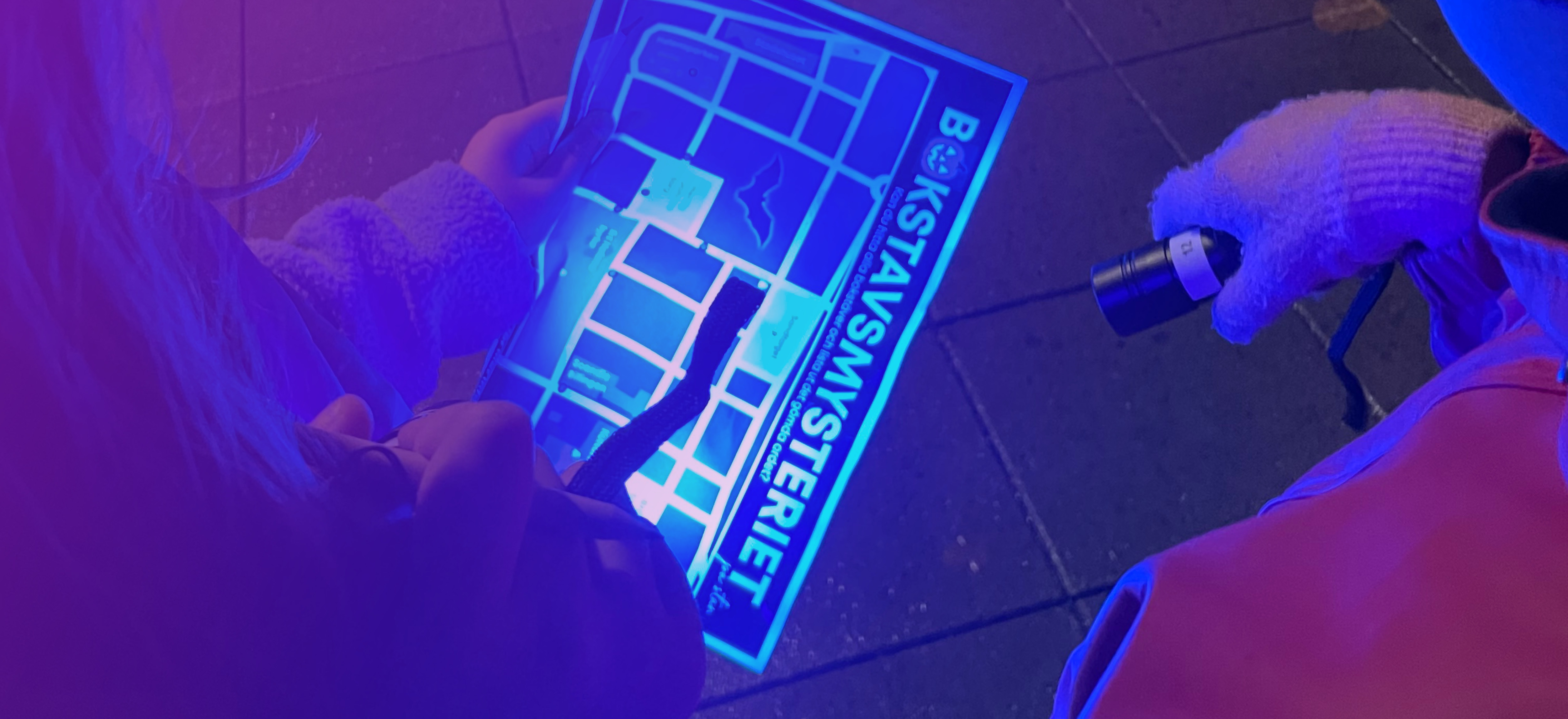 Barn som lyser på en karta med UV-ficklampor