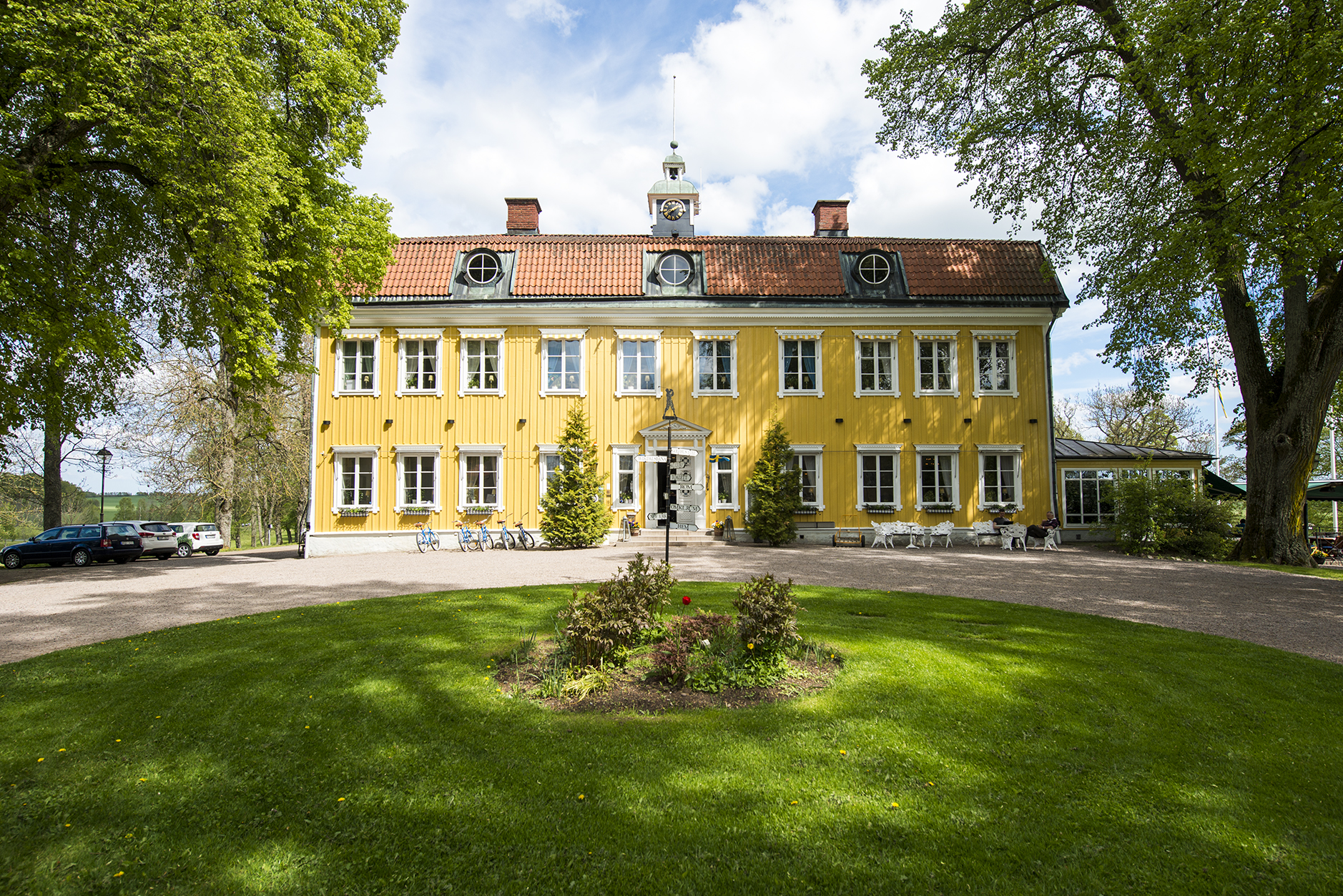 En bild på en gul herrgårdsbyggnad