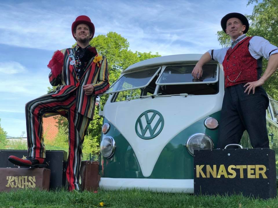 Två män på styltor i ett publikhav.