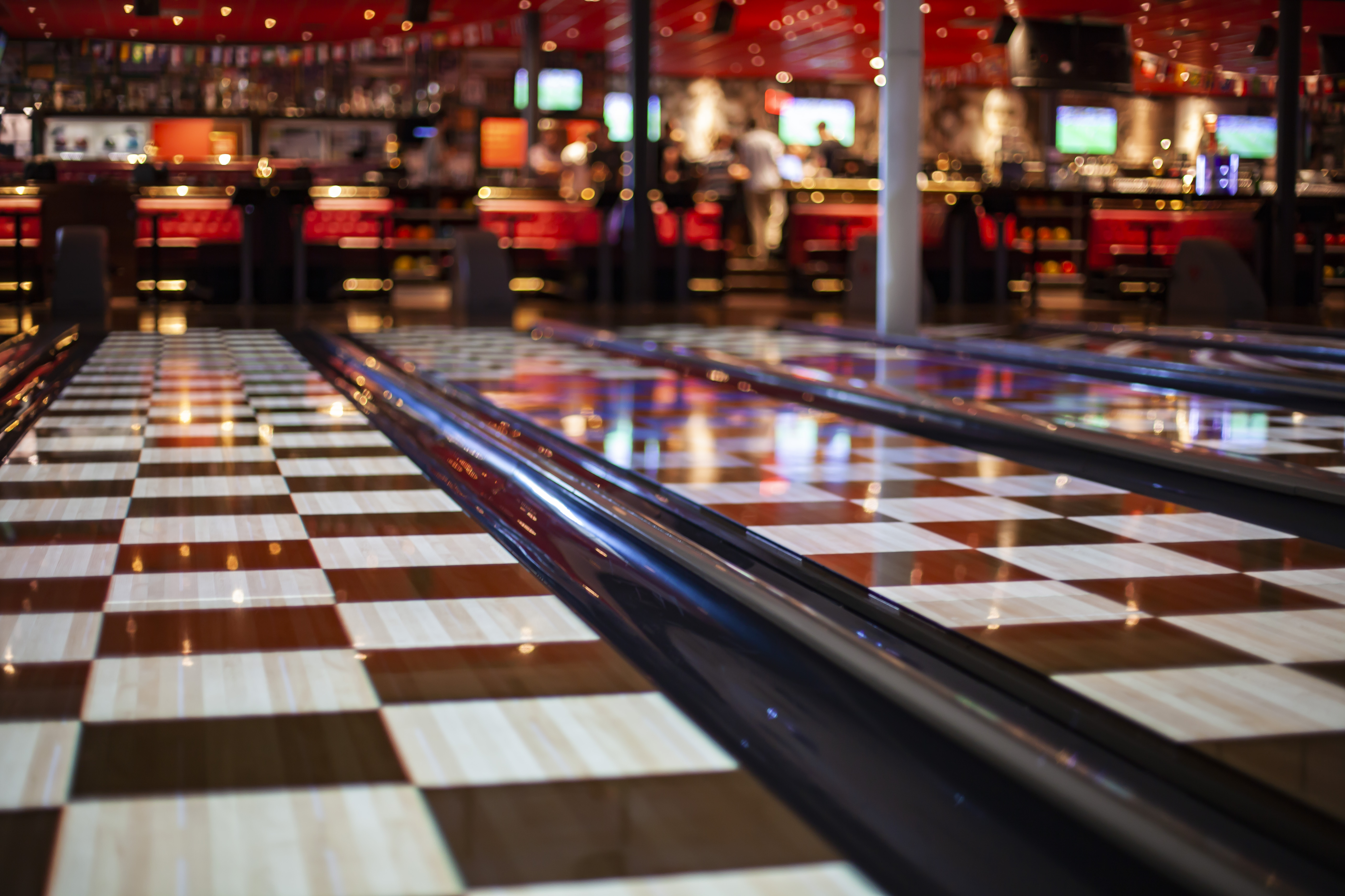 Schackrutig bowlingbana med en bar i bakgrunden.