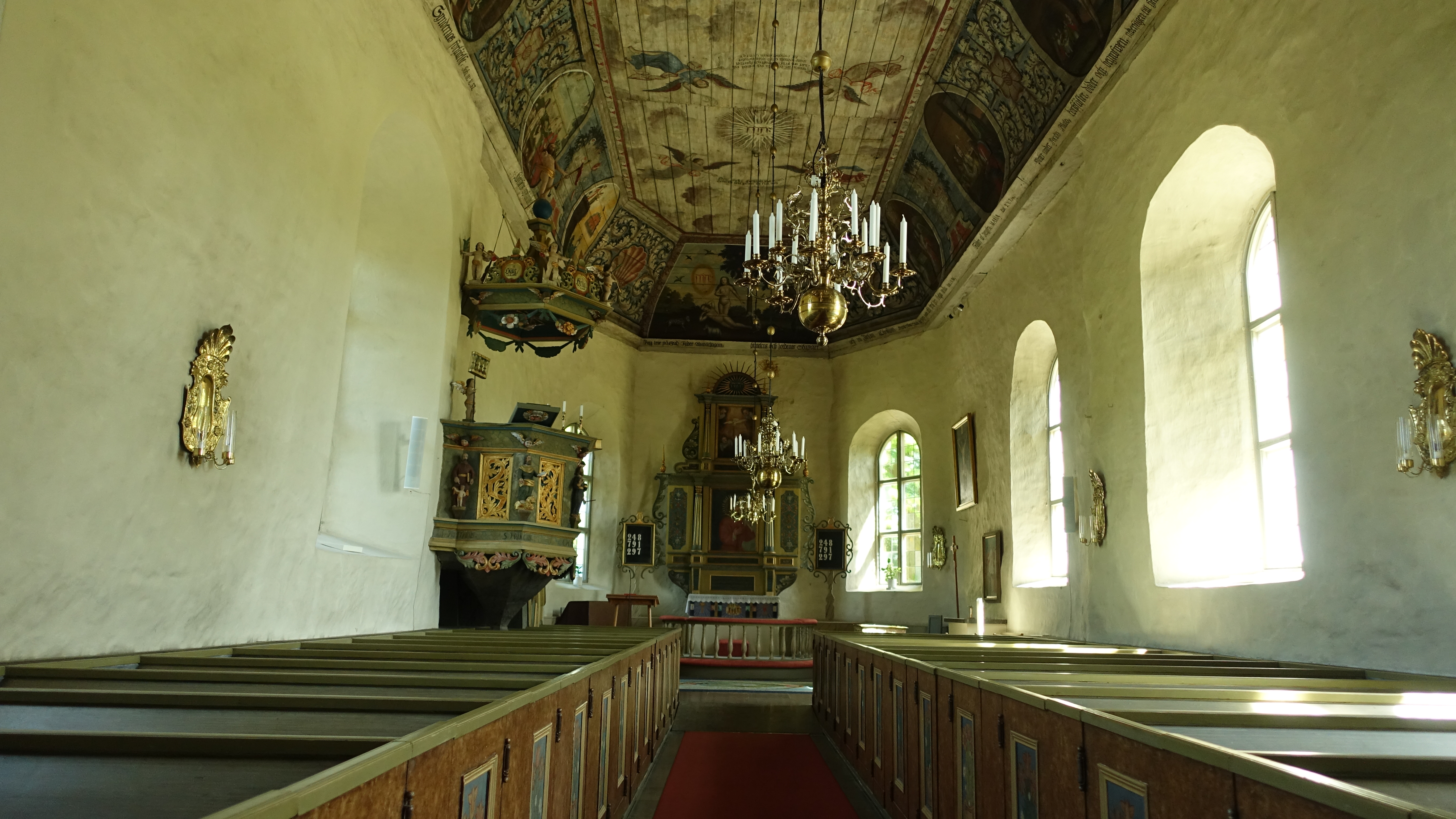 Insidan av Flistad kyrka med vacker målning i taket.