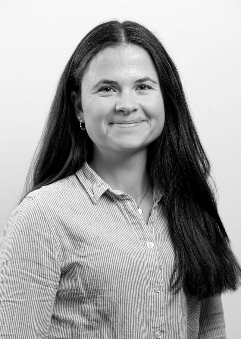 Bild av en kvinna med långt mörkt hår iklädd en smårandig skjorta. 