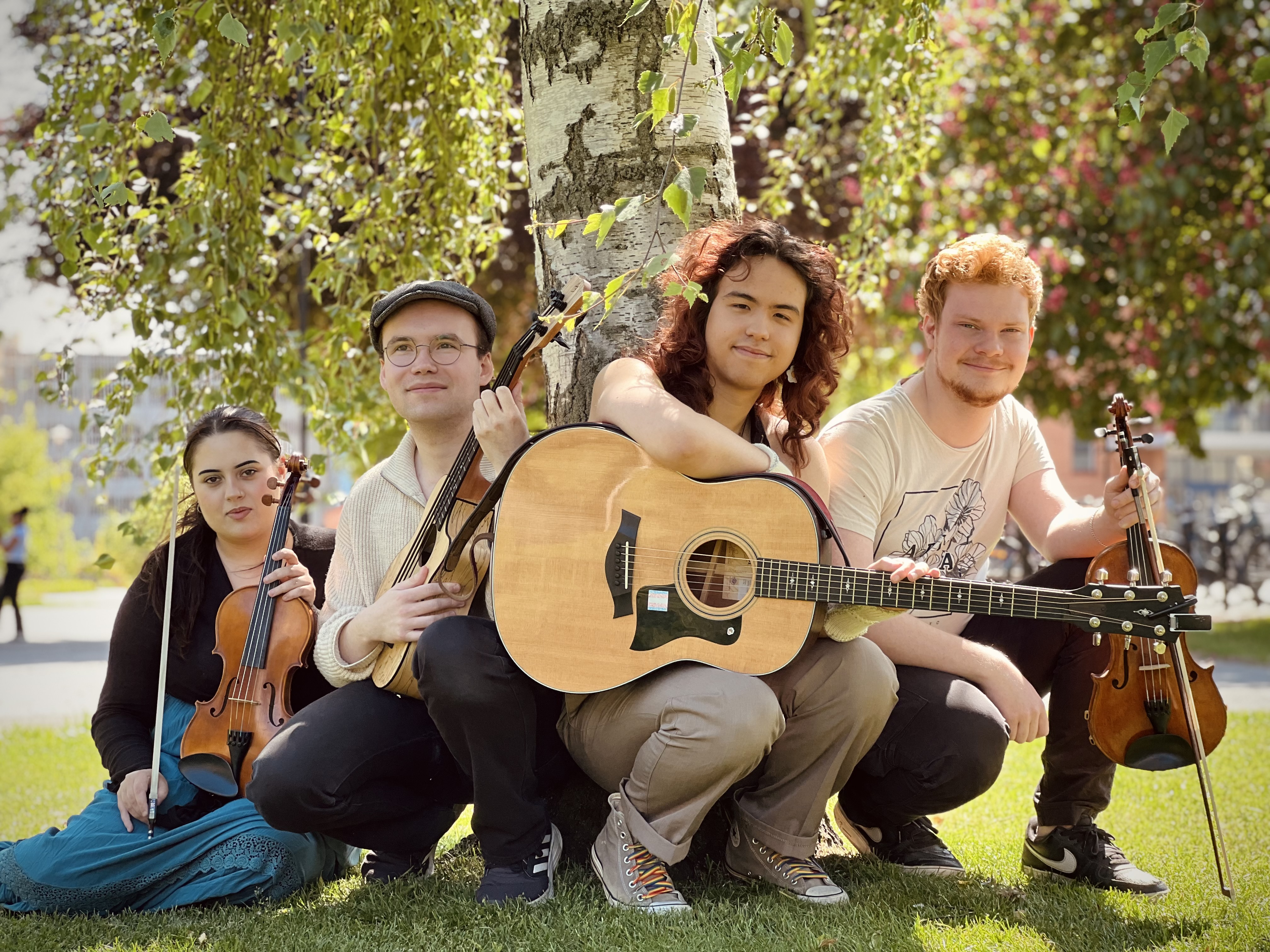 Fyra killar med instrument som tittar in i kameran.