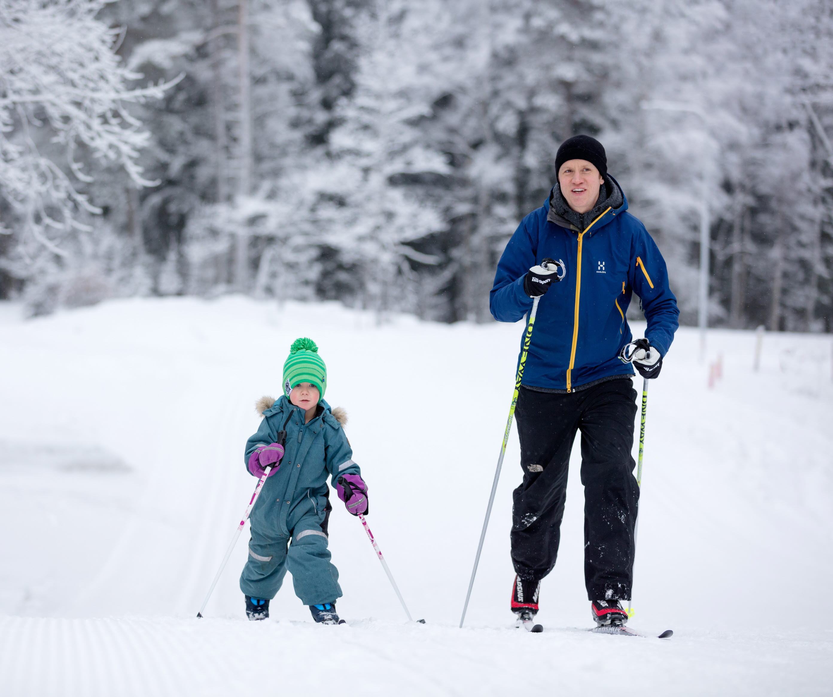 Familj med barn som åker längdskidor i skidspåret på Billingen. 