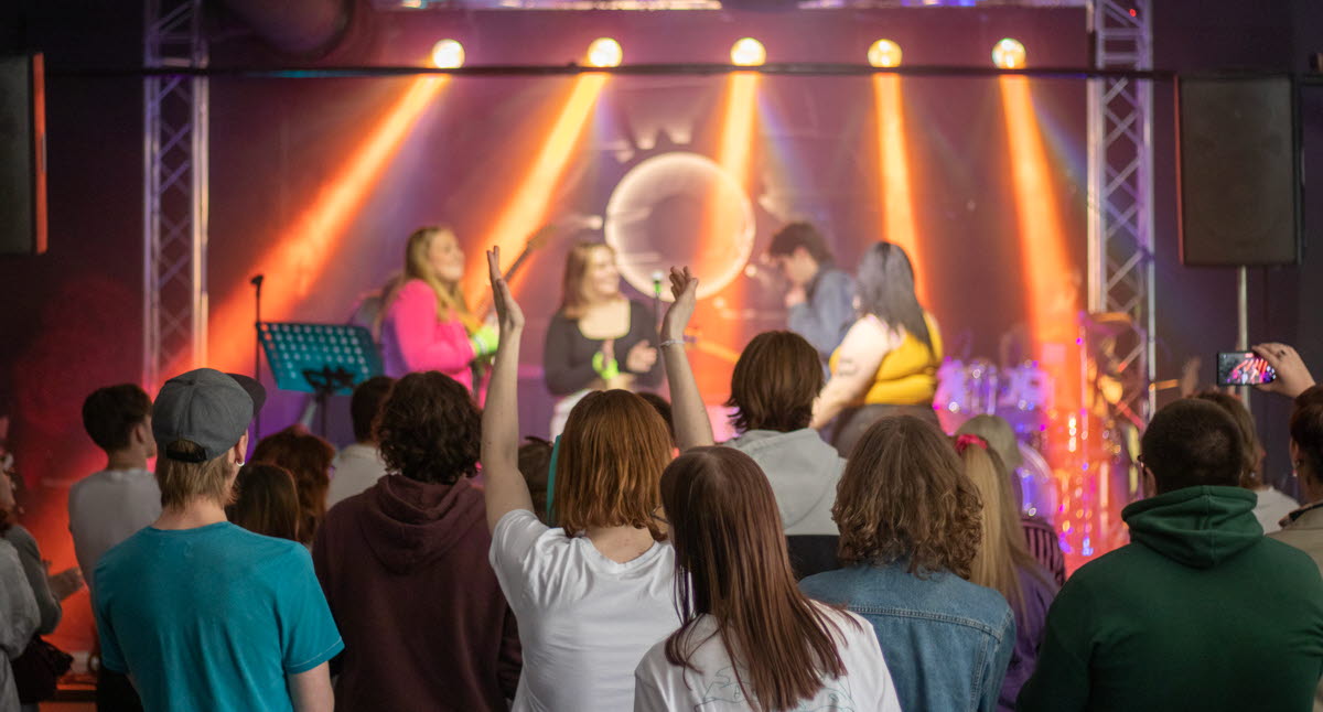 En scen med artister och ett folkhav framför.