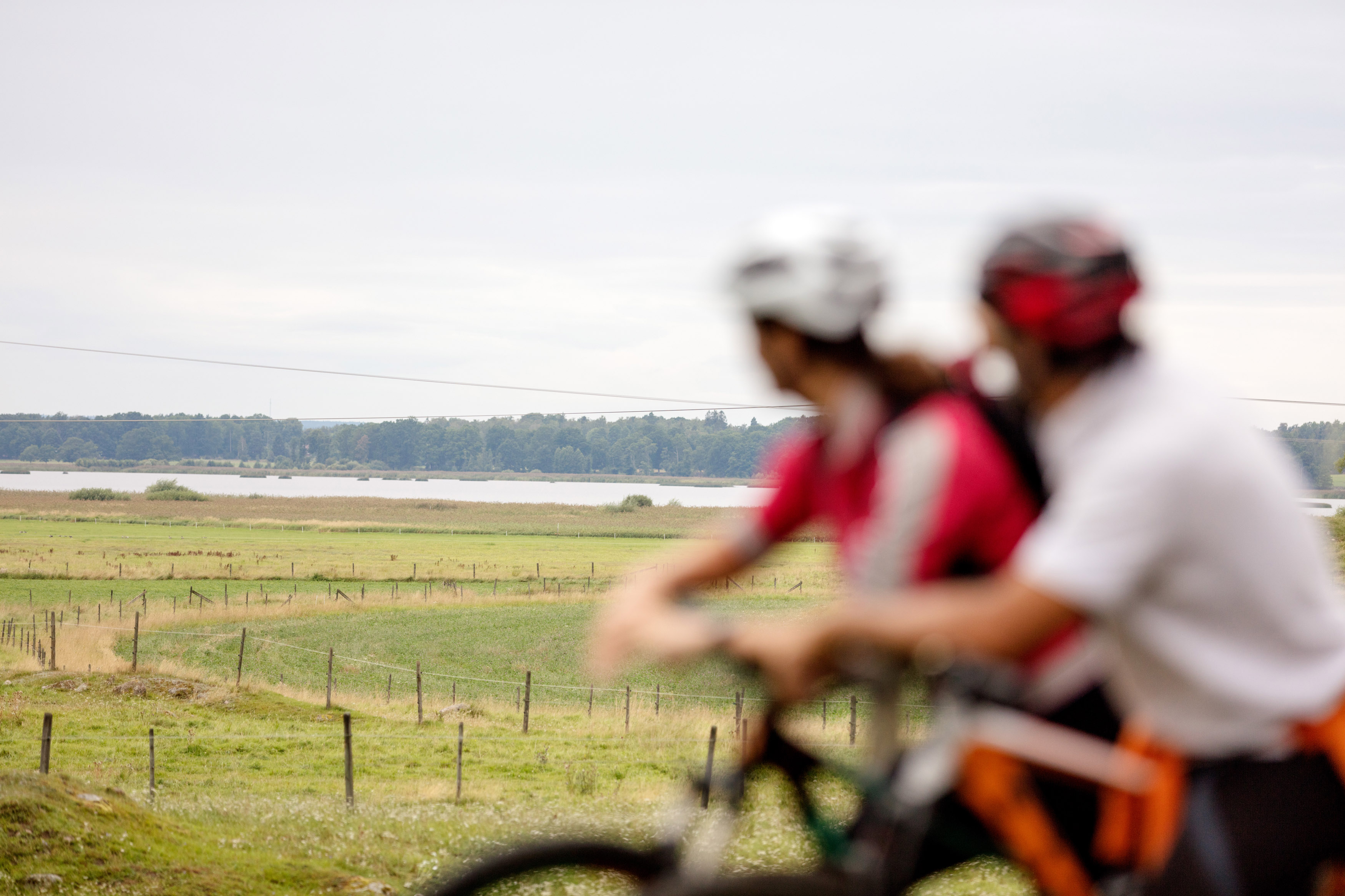 Två personer på cyklar blickar ut över slättlandskapet. 