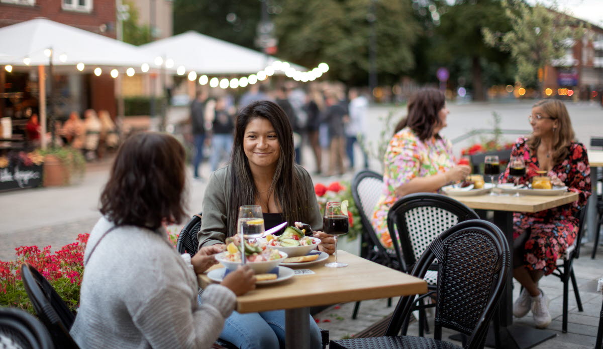 En grupp kvinnor sitter vid ett bord och äter mat