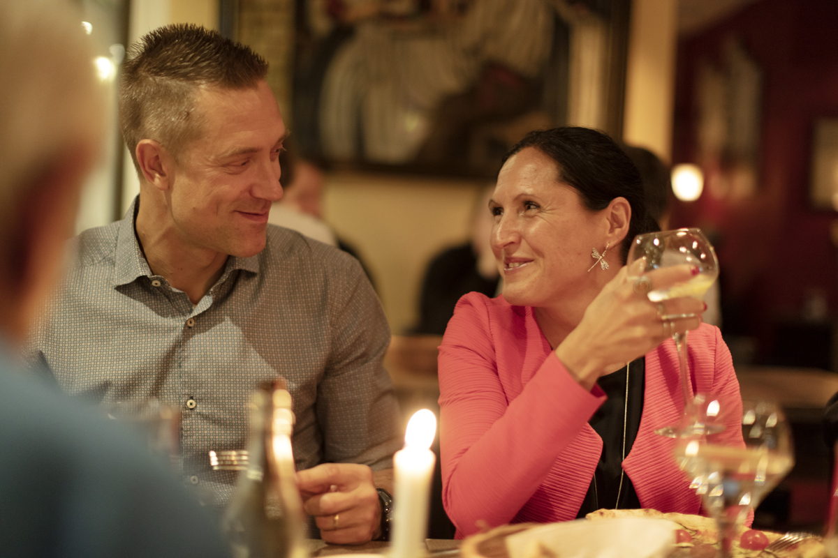 En man och en kvinna sitter på restaurang och ler mot varandra.