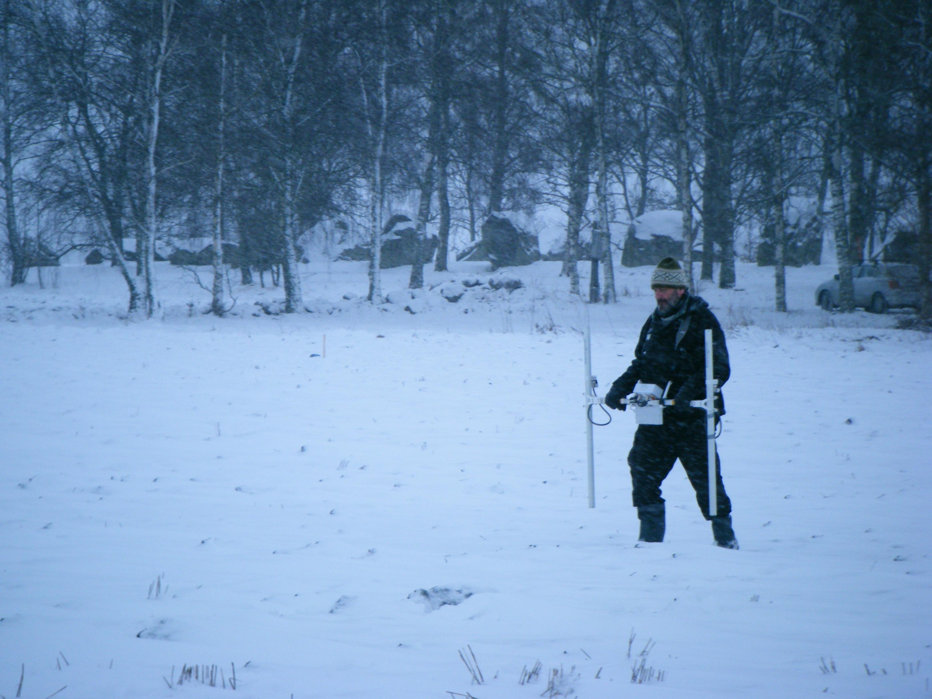 En man gå med markradarutrustning utanför kulturarvet Askeberga Skeppssättning