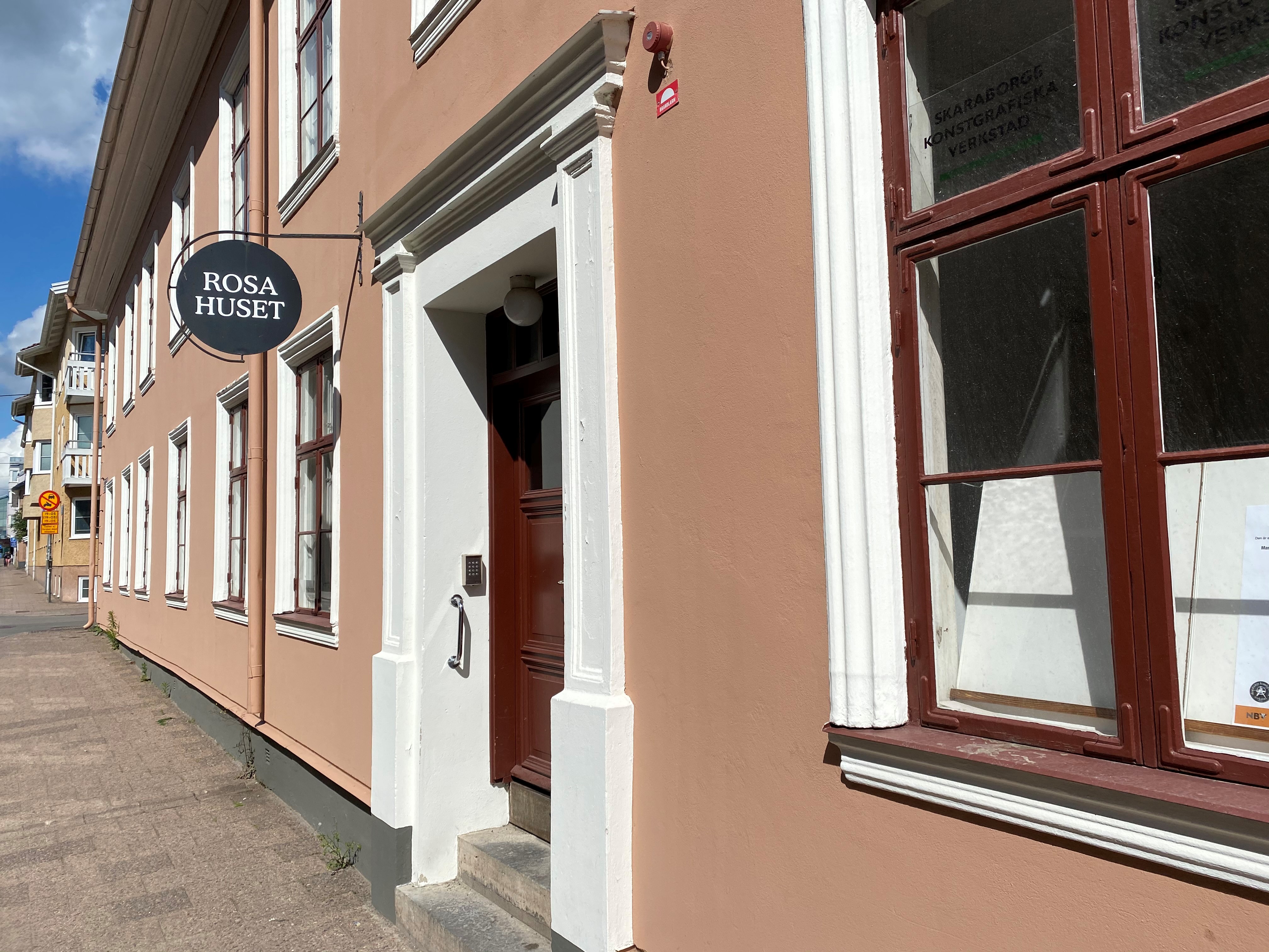 Ett rosa tegelhus med två våningar.