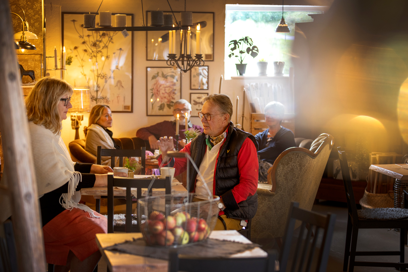 flera personer sitter och fikar i mysig miljö. 