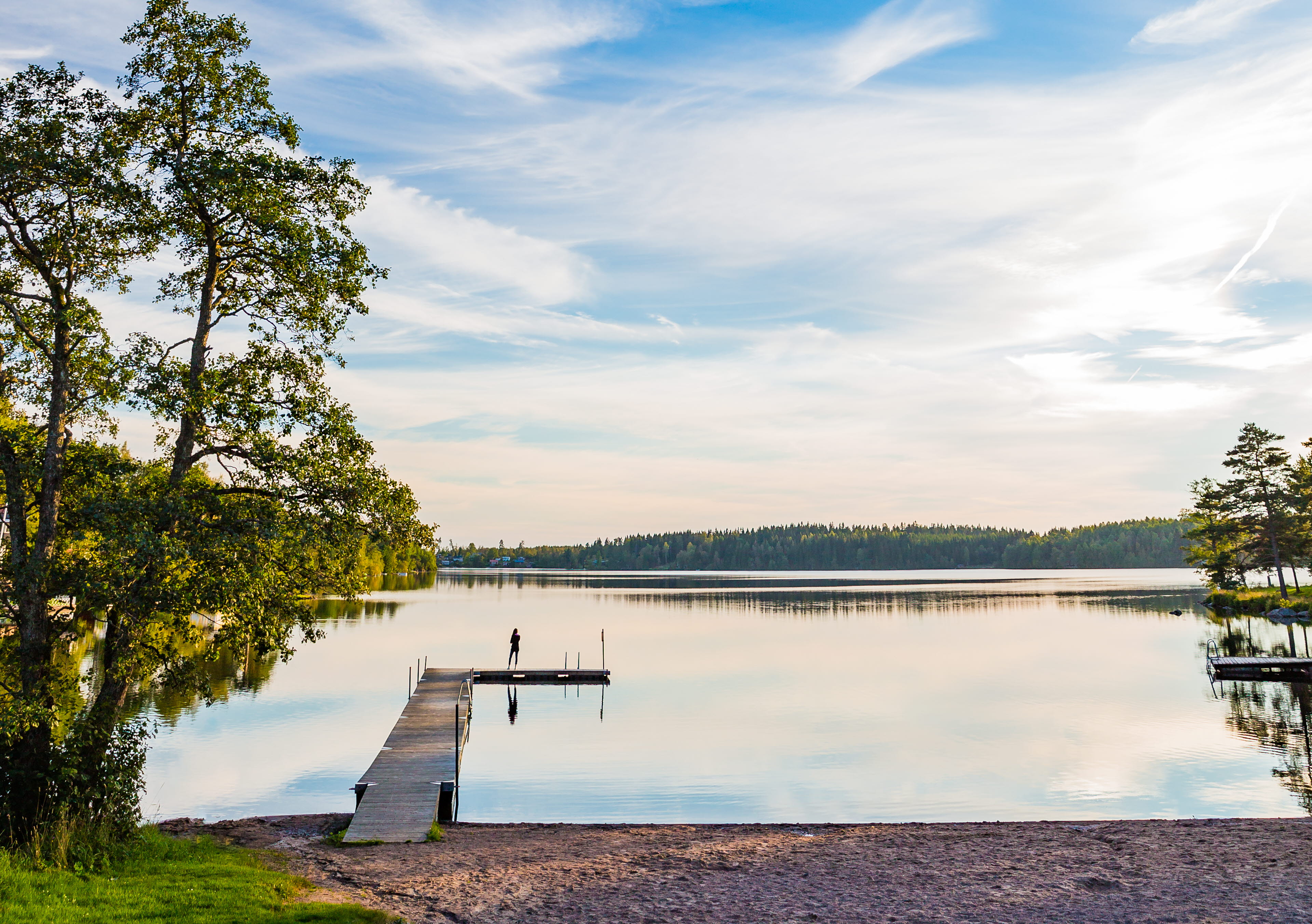 Wonderful view over a bridge in a lake with light clouds and a blue sky above. 