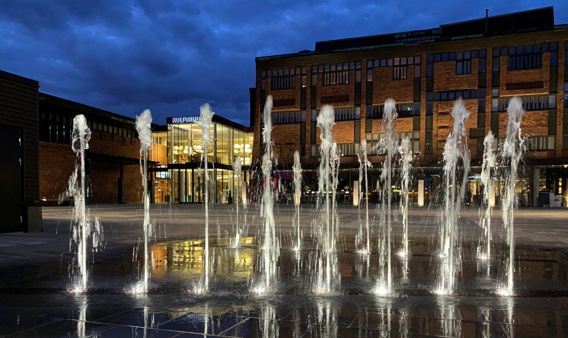 Kvällsbelysning vid en fontän som pryder en av ingångarna till Skövde kulturhus. 