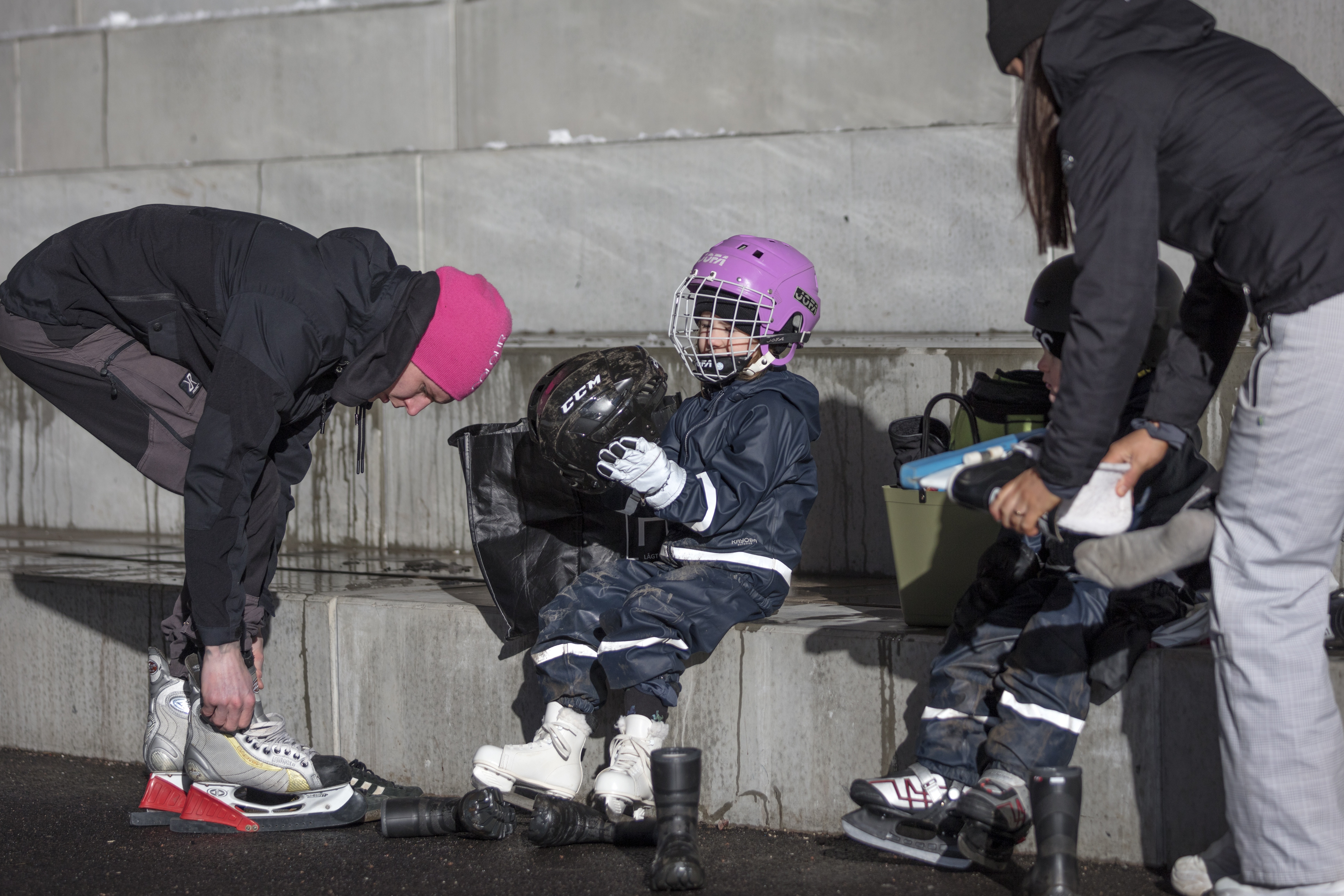 En familj tar på sig sina skridskor vid en isbana