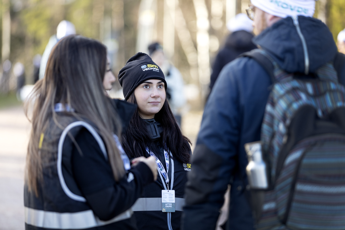 Två tjejer som pratar med en man. 