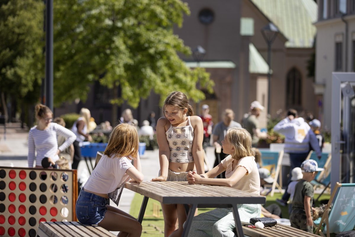 Barn sitter vid ett picknickbord och pratar.
