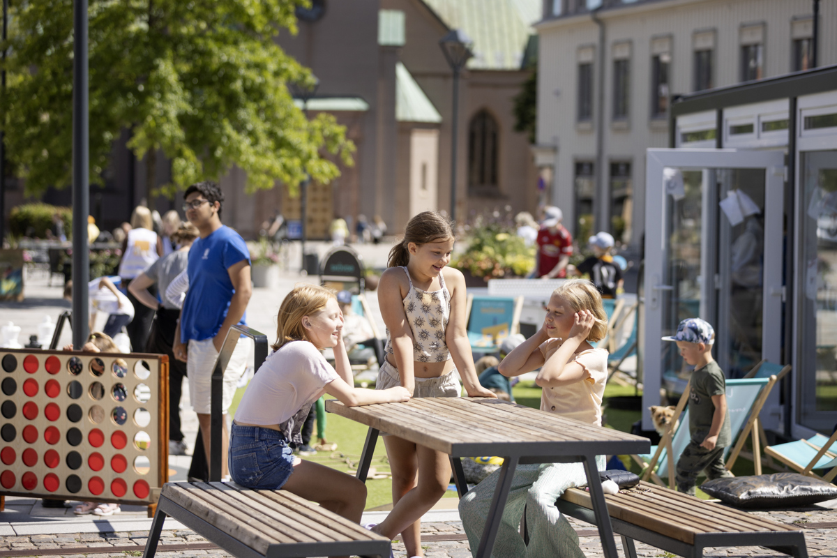 Tre tjejer hänger vid ett bord på Sommartorg . 