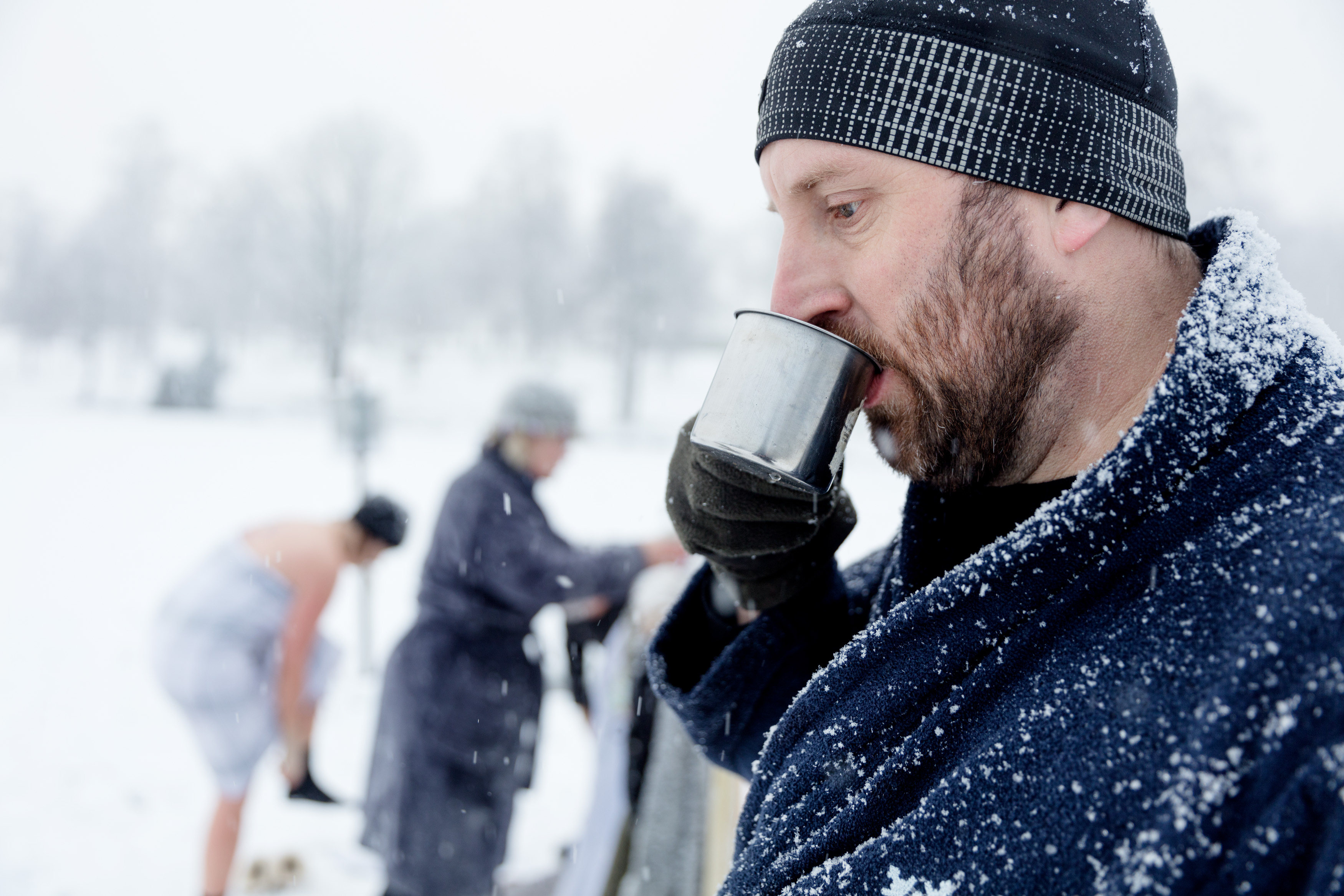 Winter swimmer drinks a hot beverage in a snowy landscape at Simsjön in Skövde.