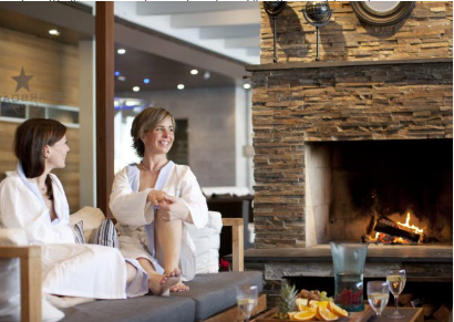 Kvinnor njuter vid brasan i vita badrockar