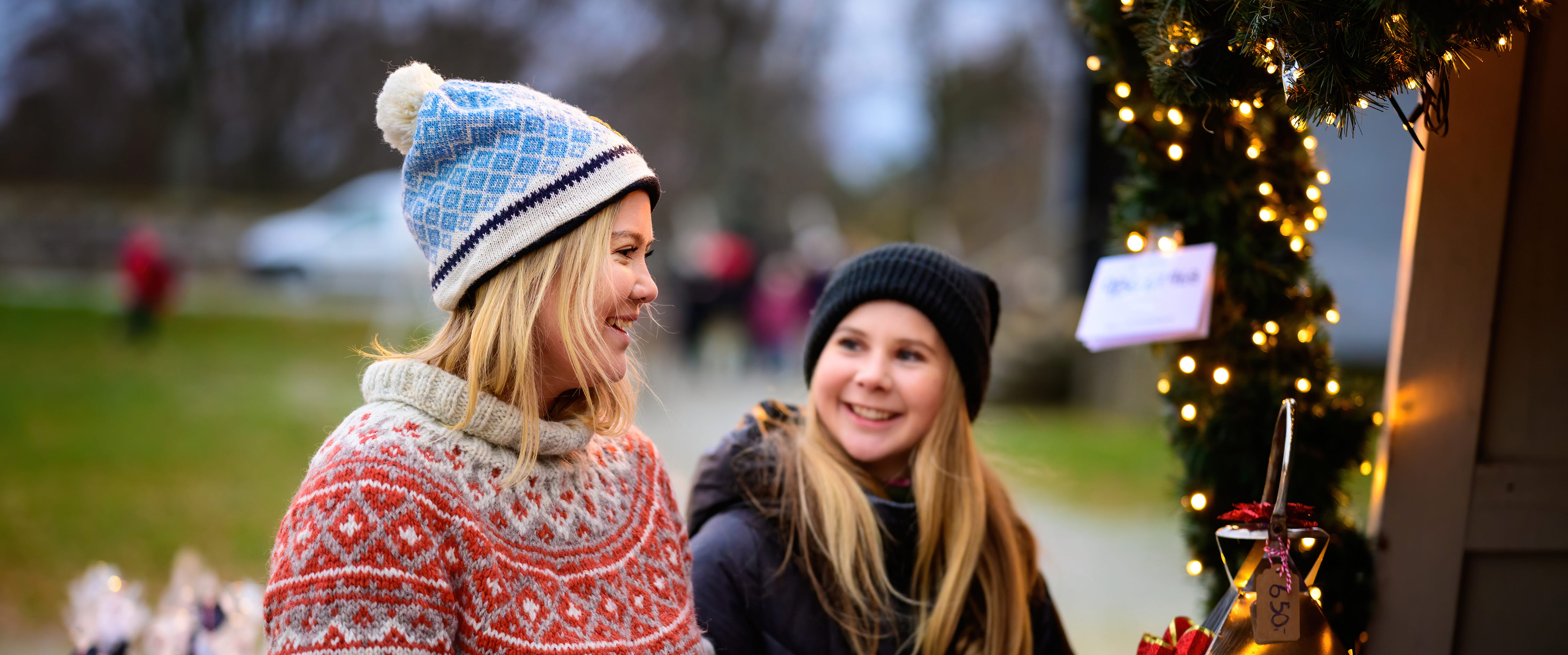 Två tjejer promenerar på julmarknad