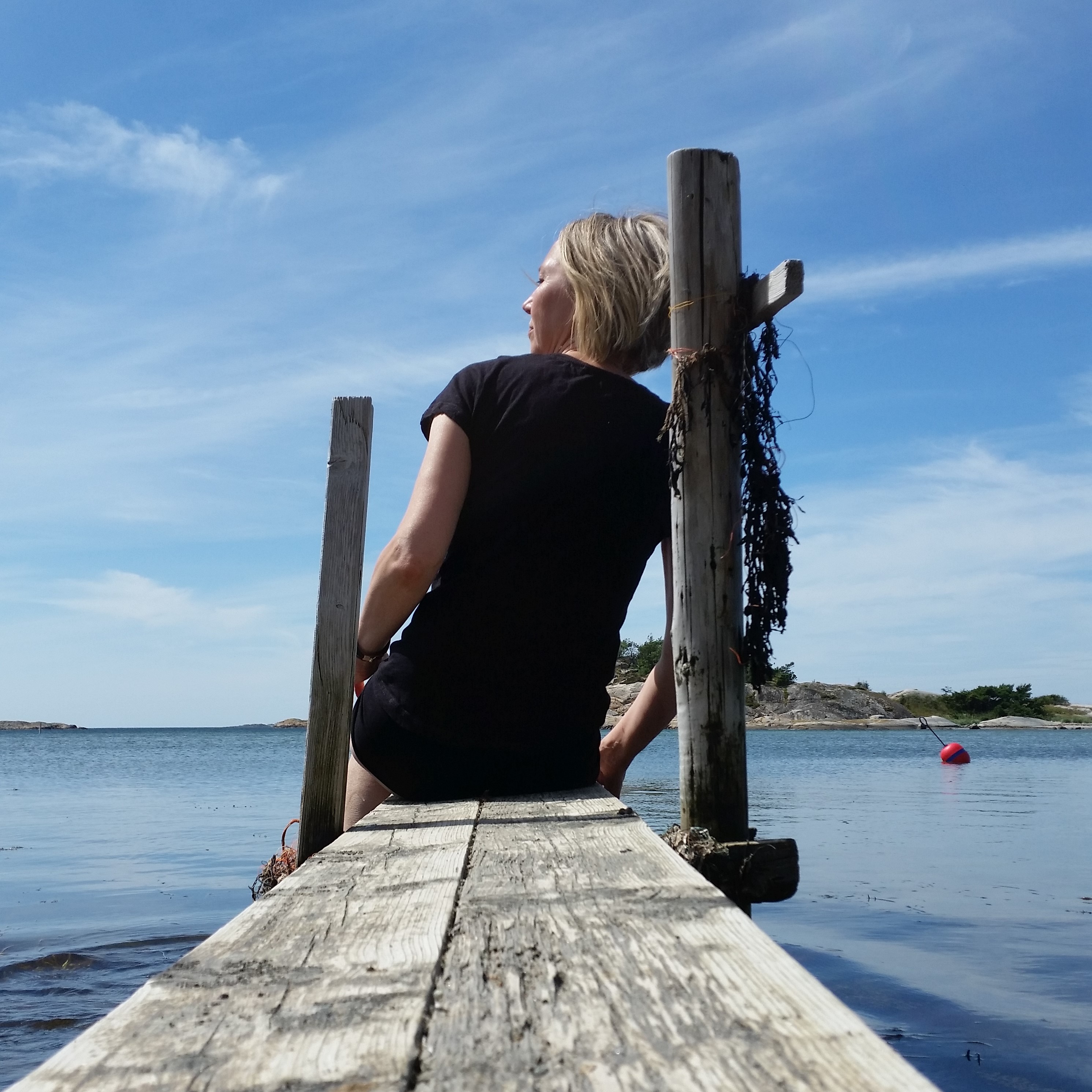 Kvinna sitter på brygga 