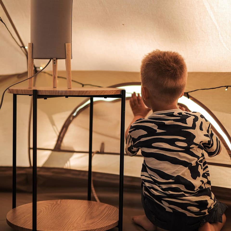 En pojke sitter i ett tält