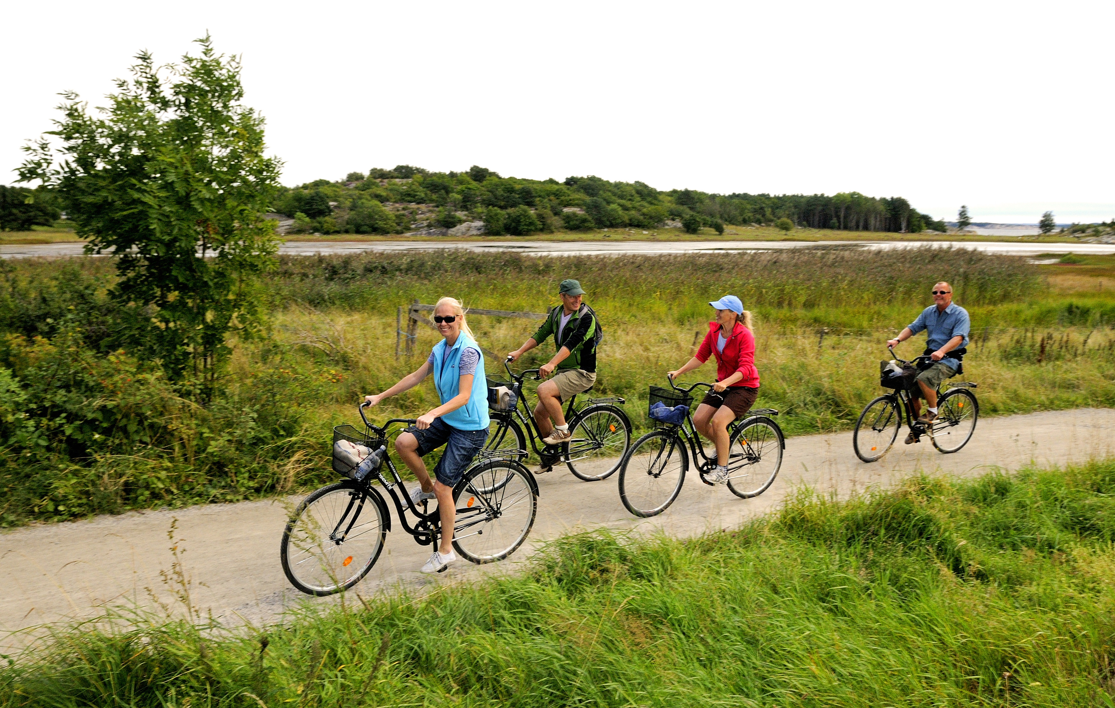 Four people are biking along a gravel road at South Koster.