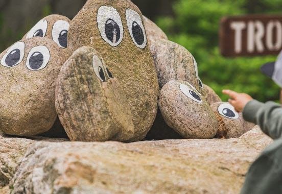 Children point to stone trolls