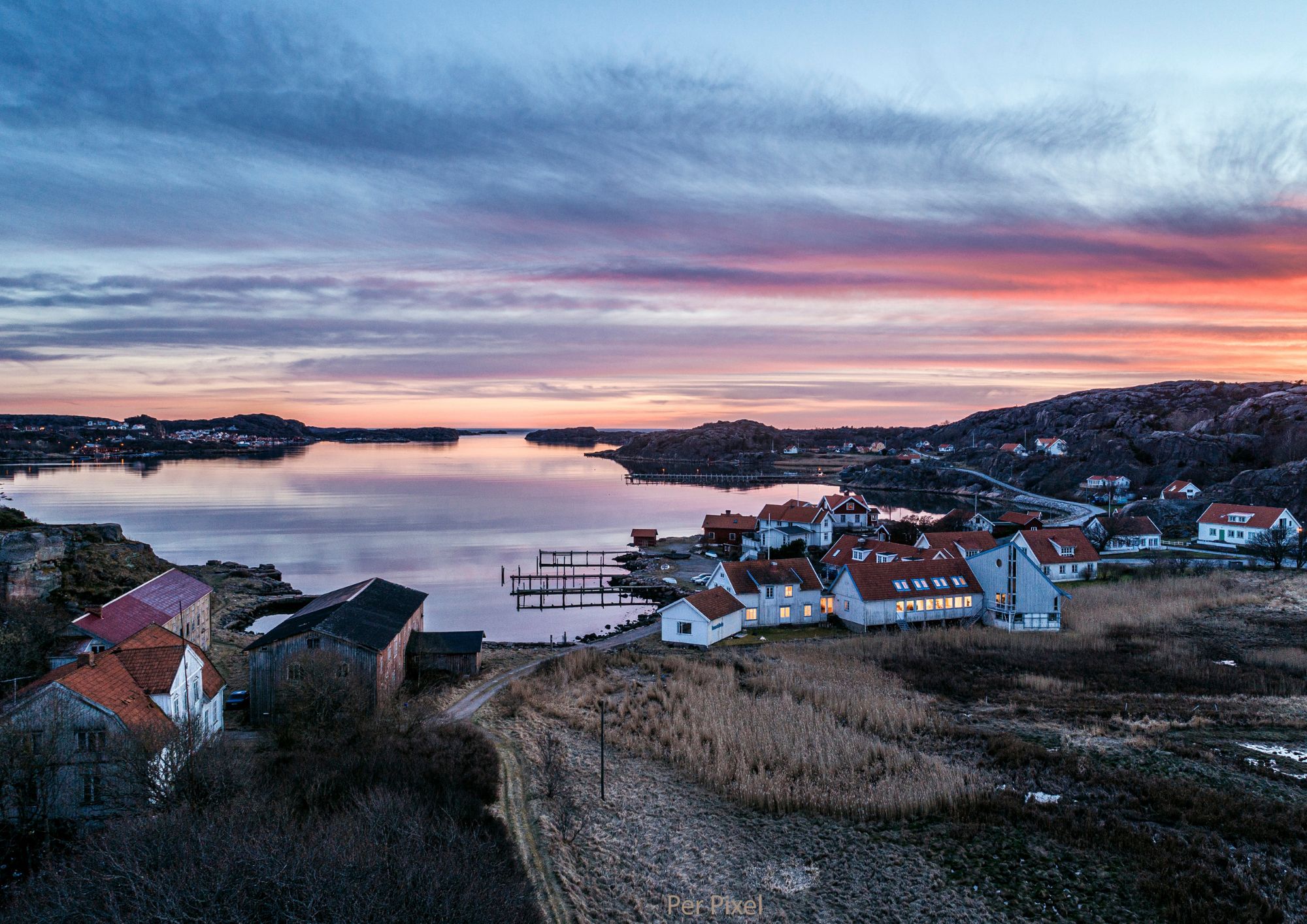 Vy över Bottnafjorden med Gerlesborg i förgrunden vid skymning. Rosa-lila himmel
