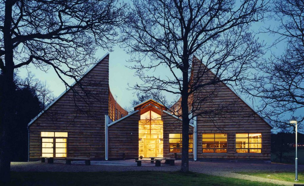 Bilden visar Vitlycke museum i skymningen med tänd belysning