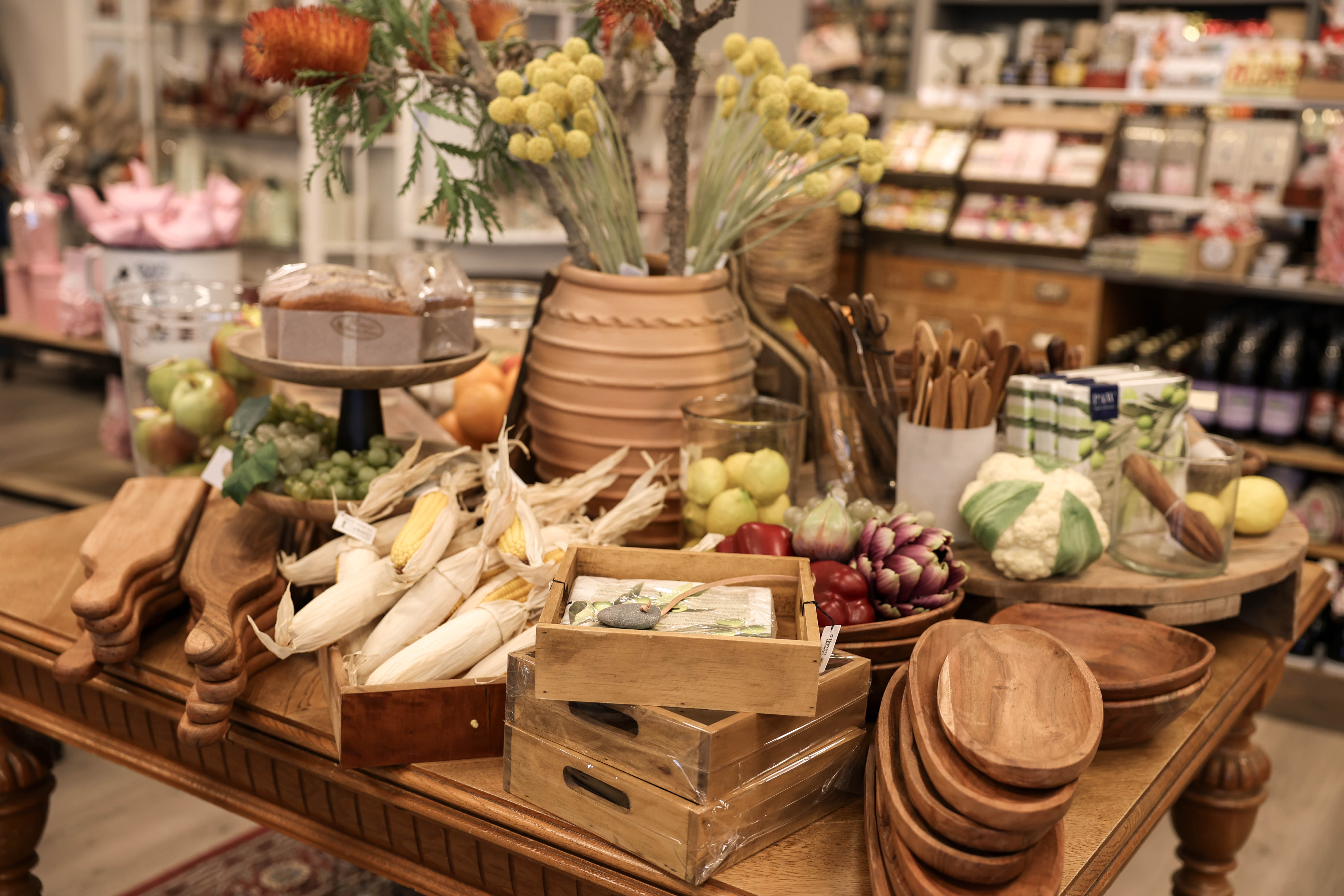 Butik med rustika möbler och produkter i form av träfat, grönsaker och andra verklighetstrogna dekorationer.