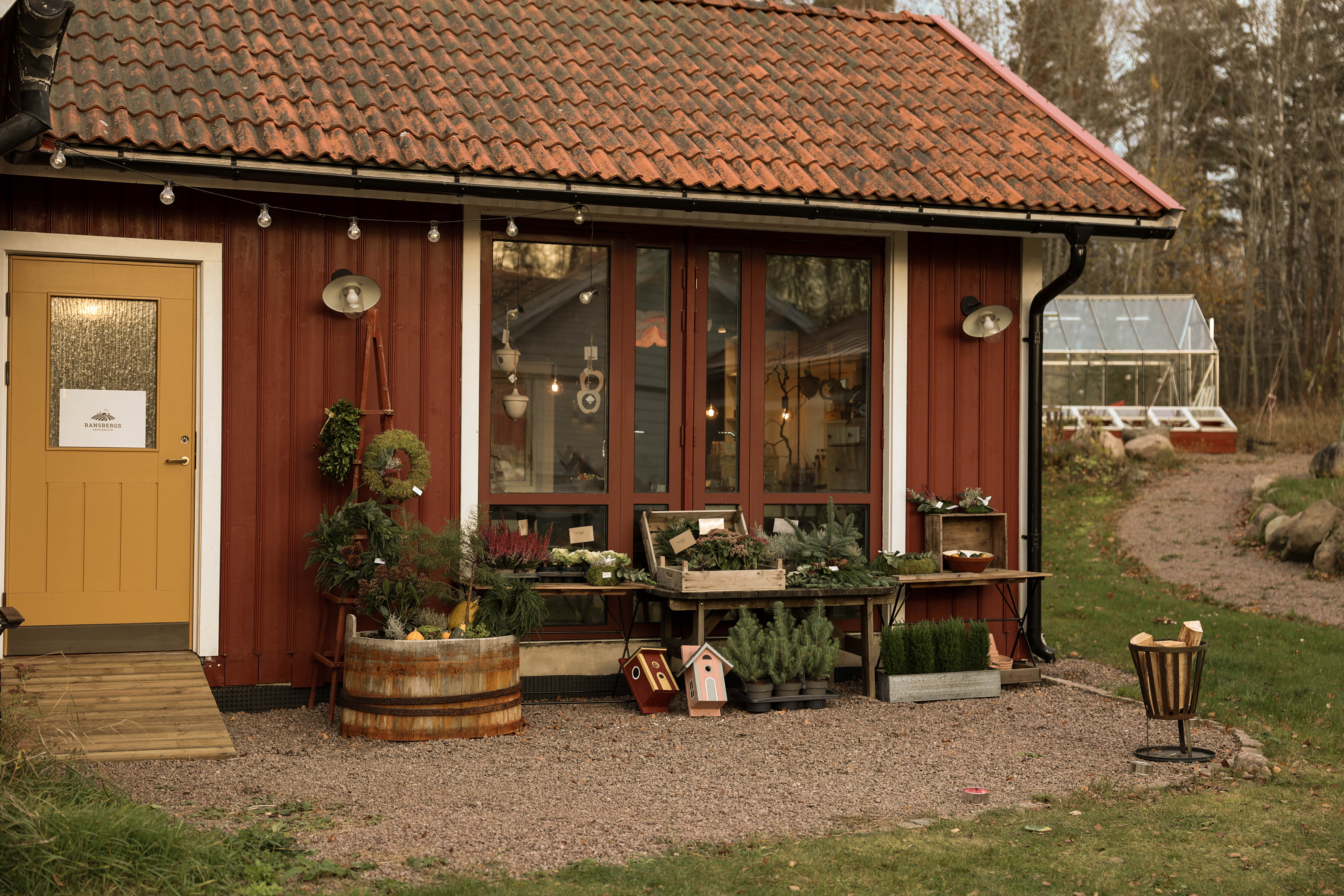 Charmig gårdsbutik med rödmålad fasad och  utomhusdekoration