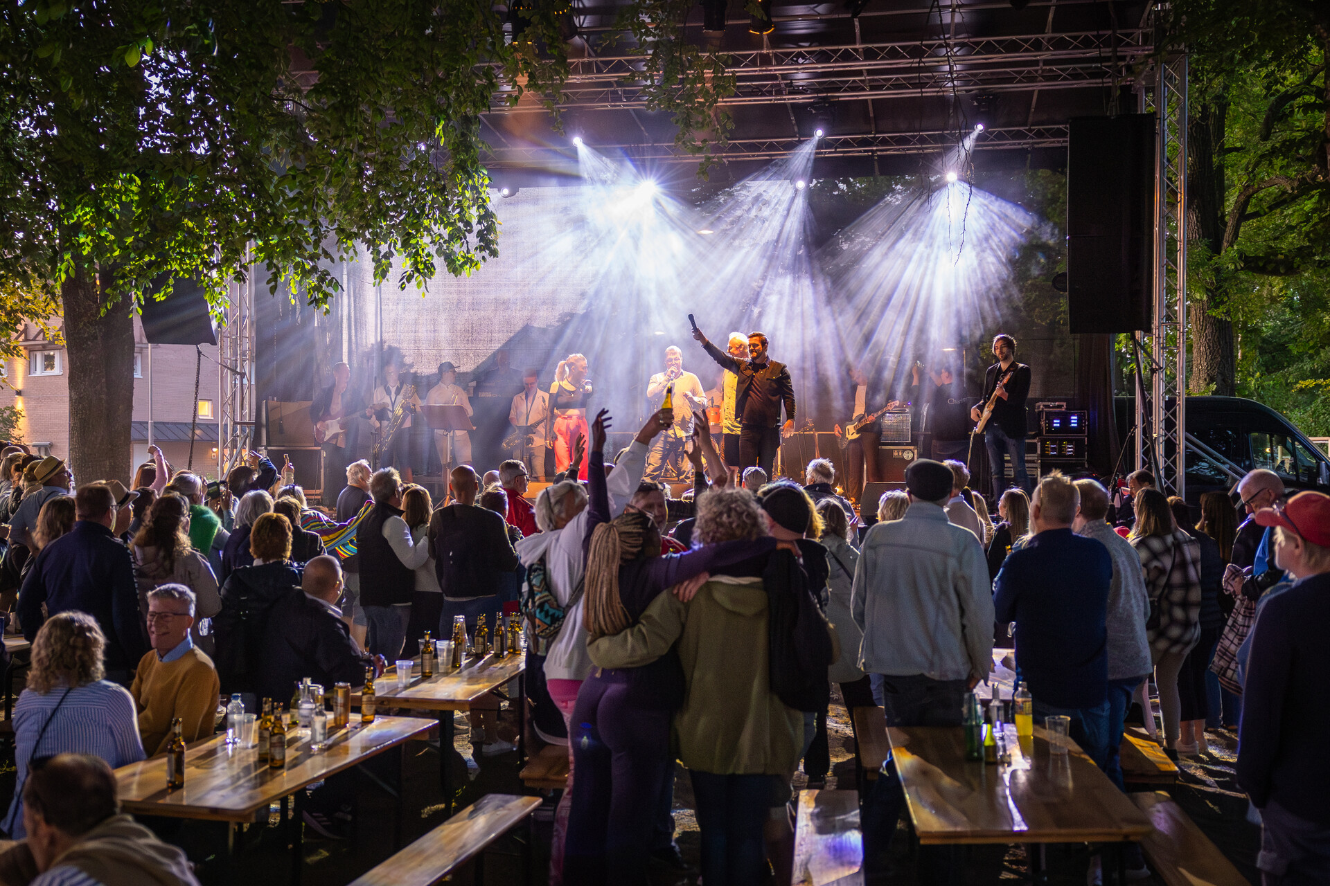 Ett band spelar på en utomhusscen på en festival framför en stor publik