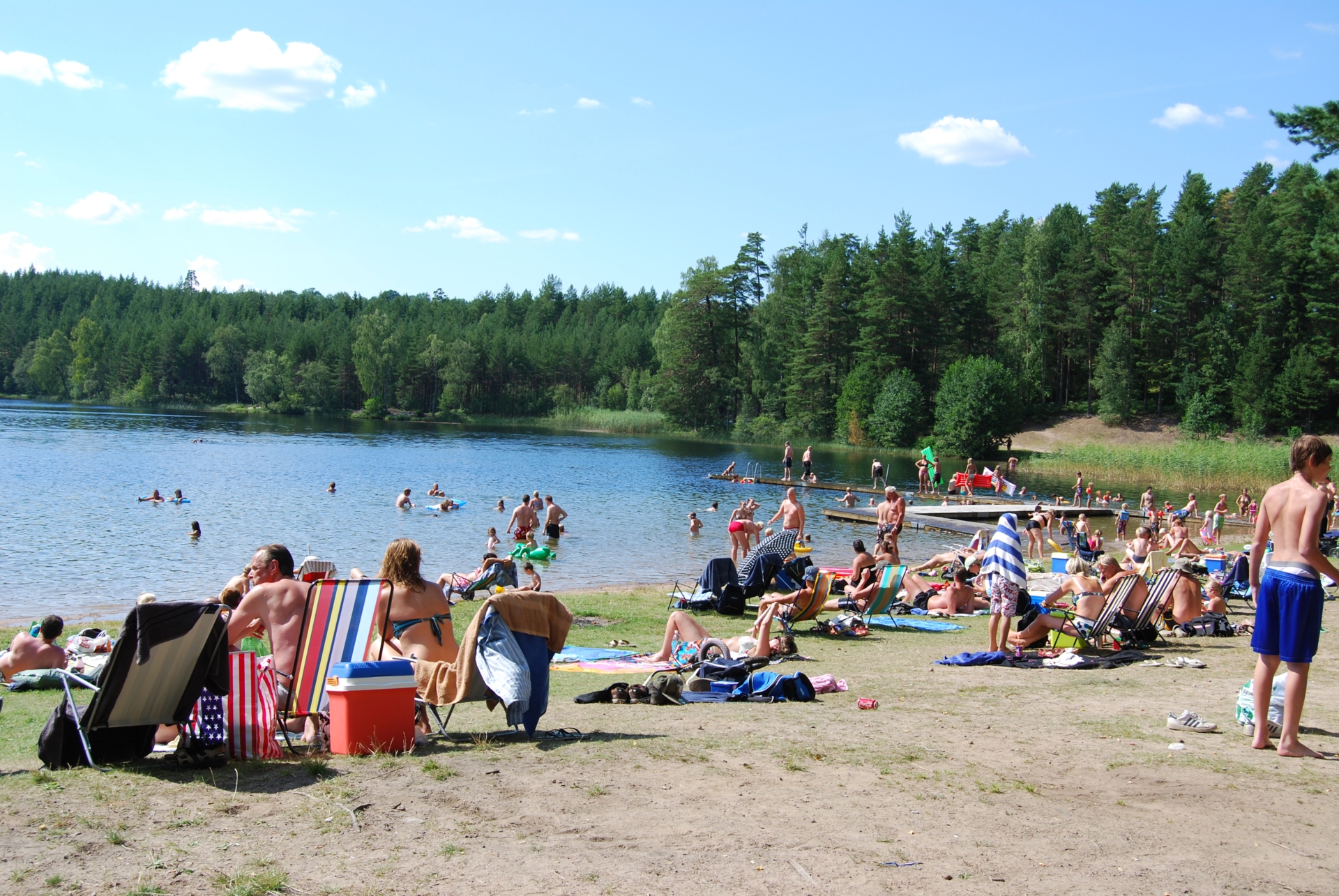Människor som solar och badar en sommardag.