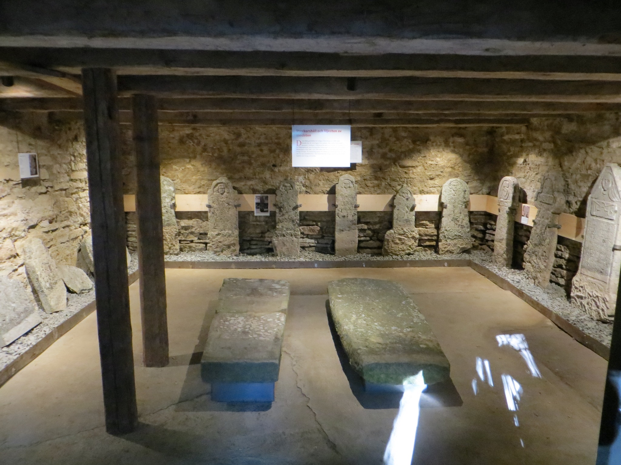 Gravstenar som står och ligger i en kalkstensbyggnad