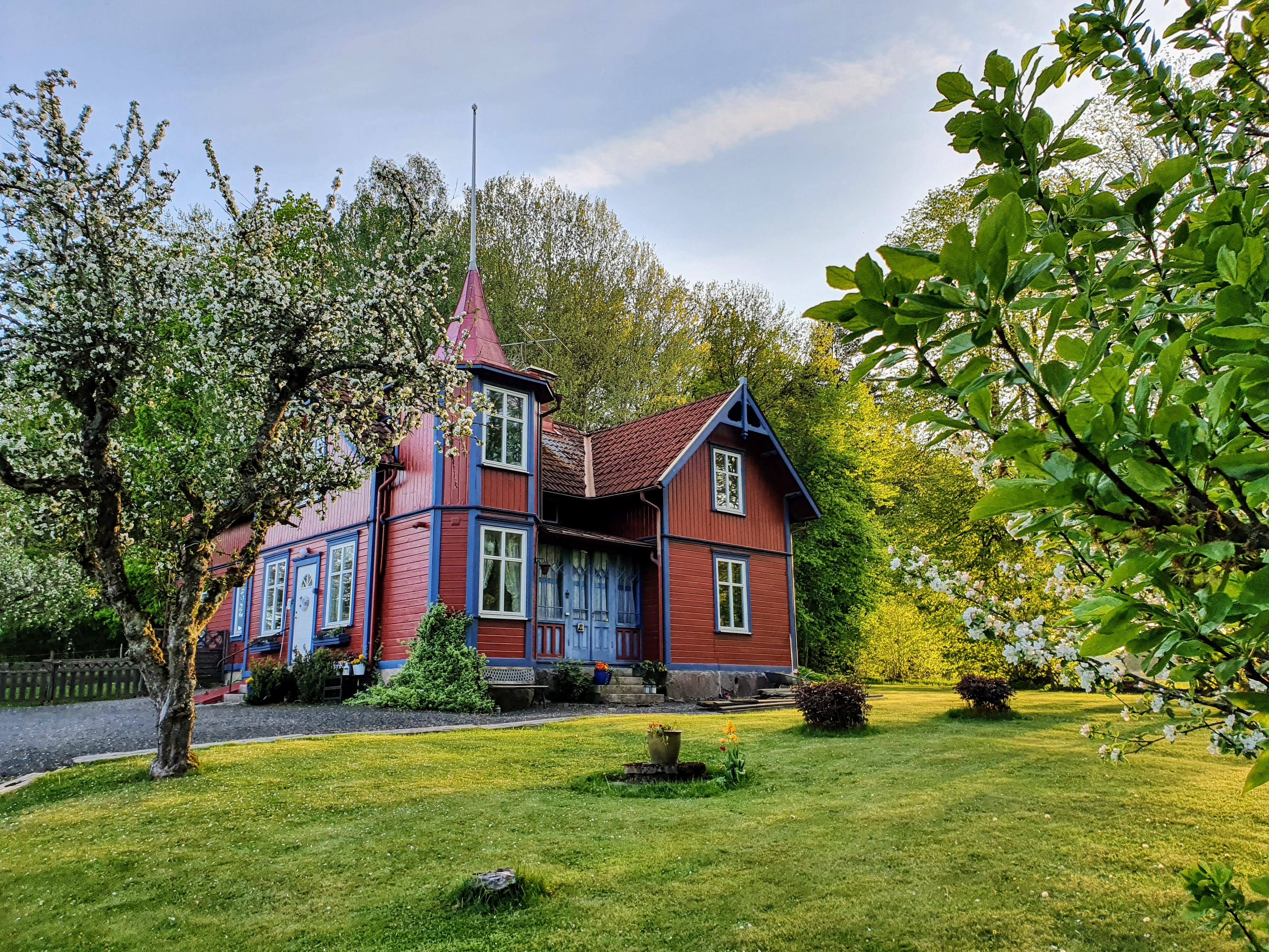 Vy över ett rött trähus med blåa knutar.