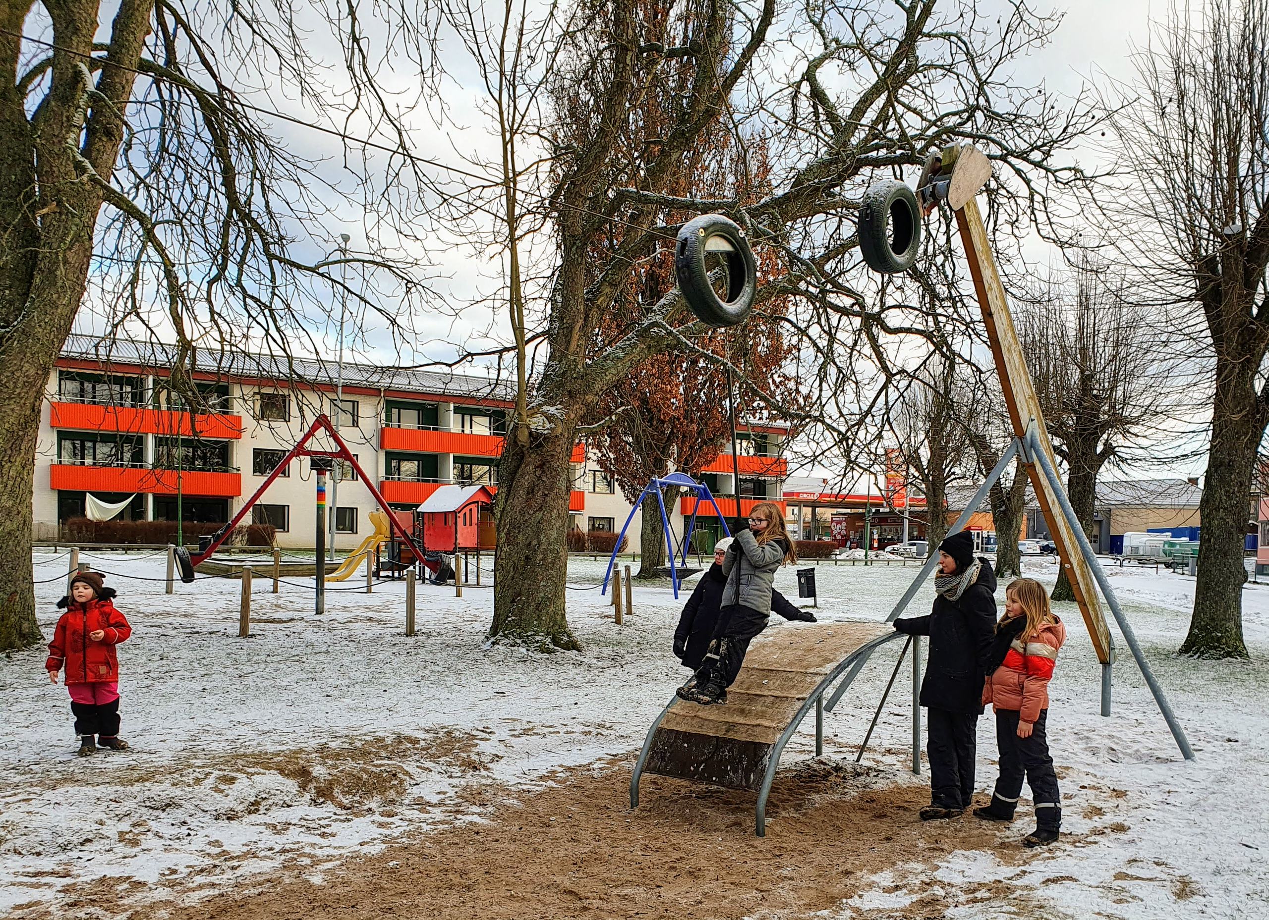 Lekande familj på lekplats i Tidaholms stadspark