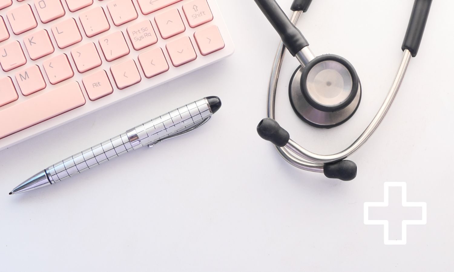 Tangentbord med rosa knappar, ett svart stetoskop och en vit penna med svarta streck på