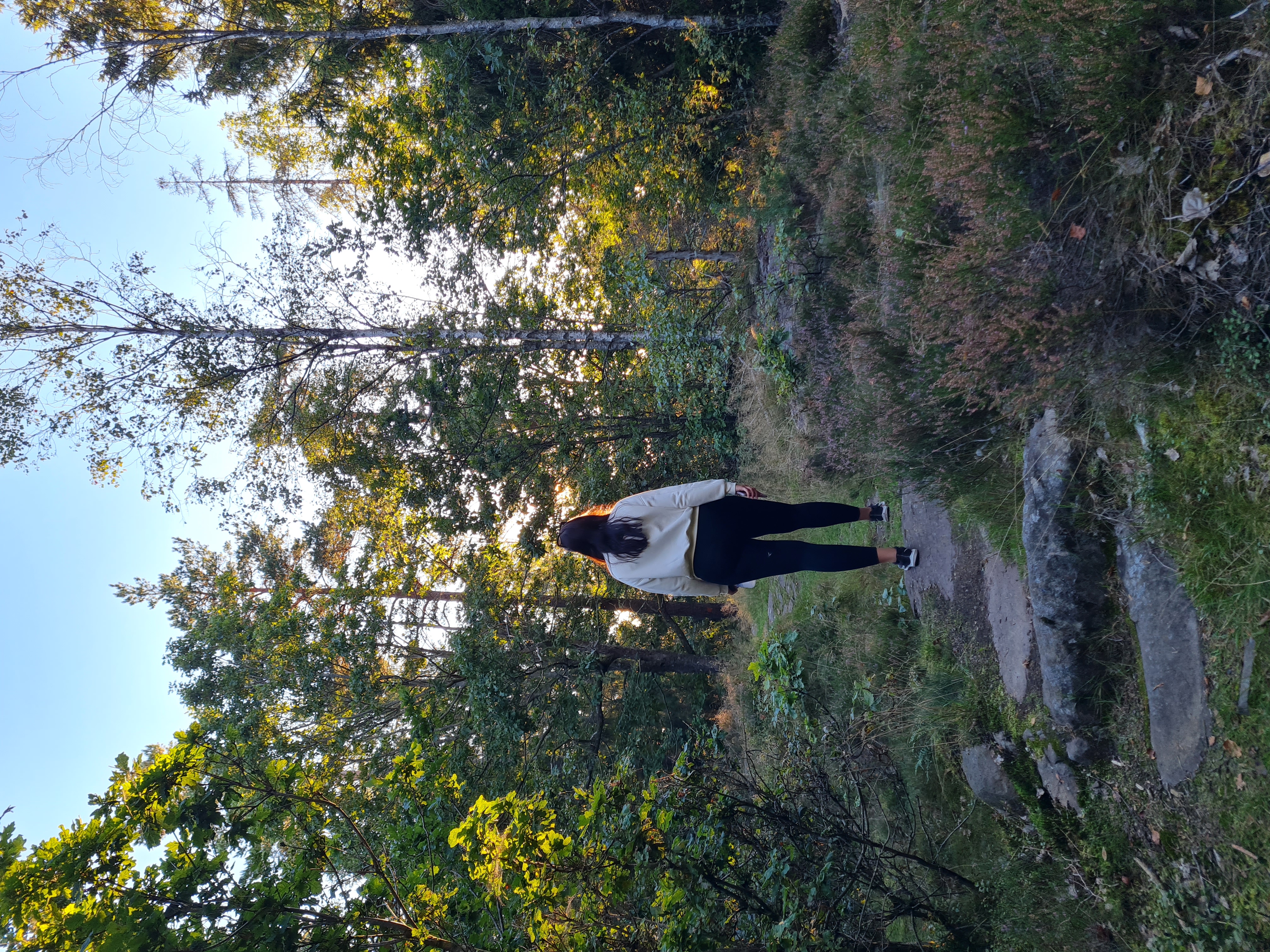 kvinna vandrar i skogen