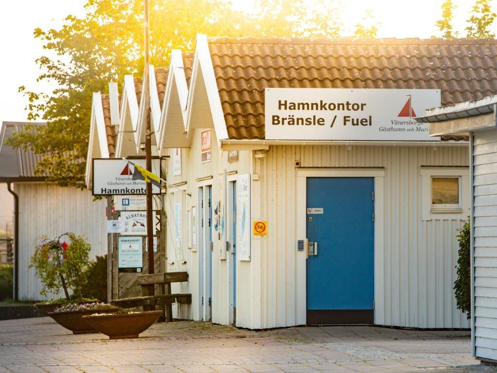 små vita hus med skylt "hamnkontor"
