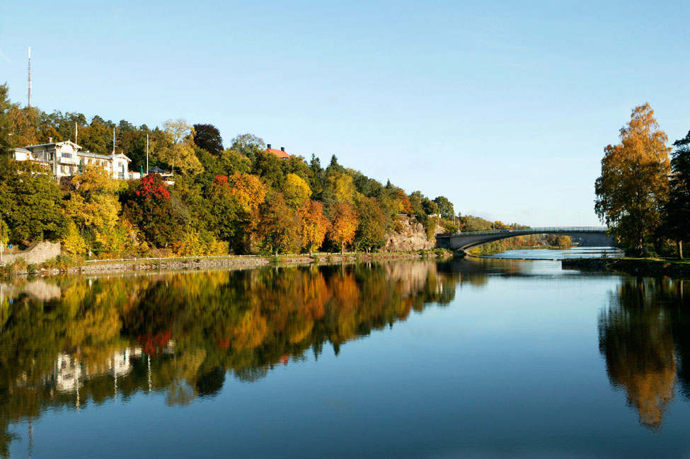 Utsikt över Göta älv och Albert Kök, Hotell och konferens omgivet av träd under hösten.