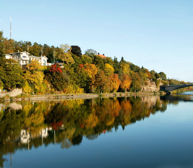 Utsikt över Göta älv och Albert Kök, Hotell och konferens omgivet av träd under hösten.