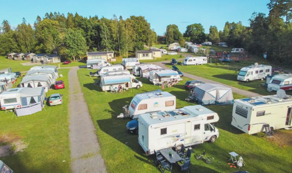 Campingplats med husbilar och husvagnar.