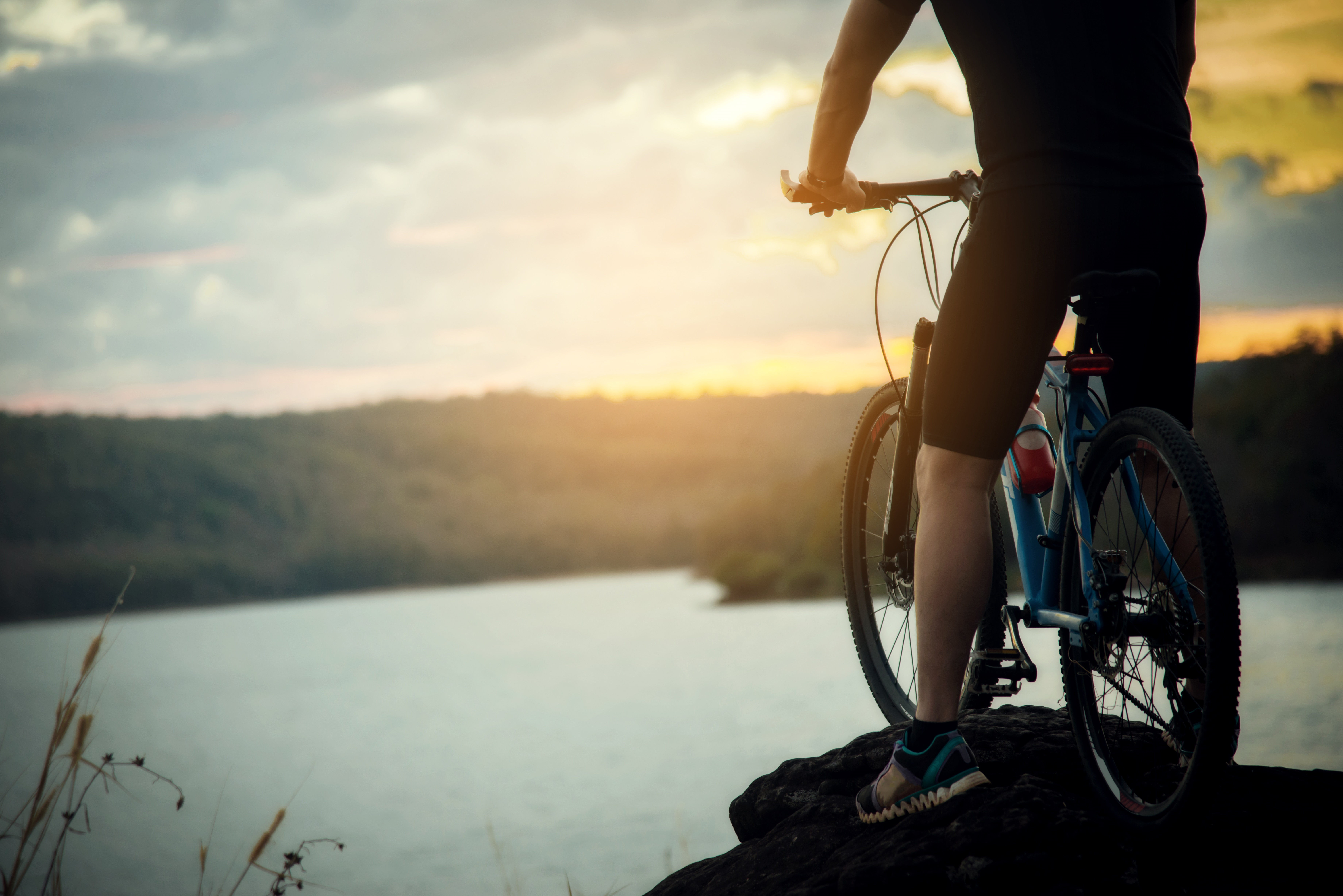 Person standing on his bike with a view over a lake