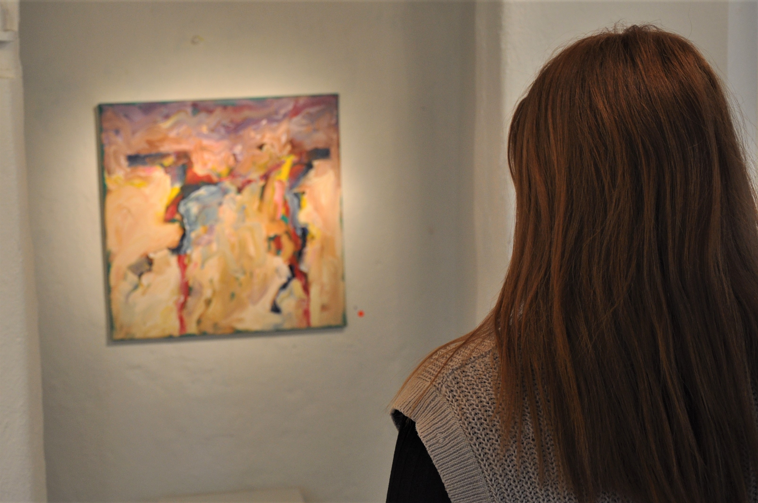 kvinna ser på hängande konst