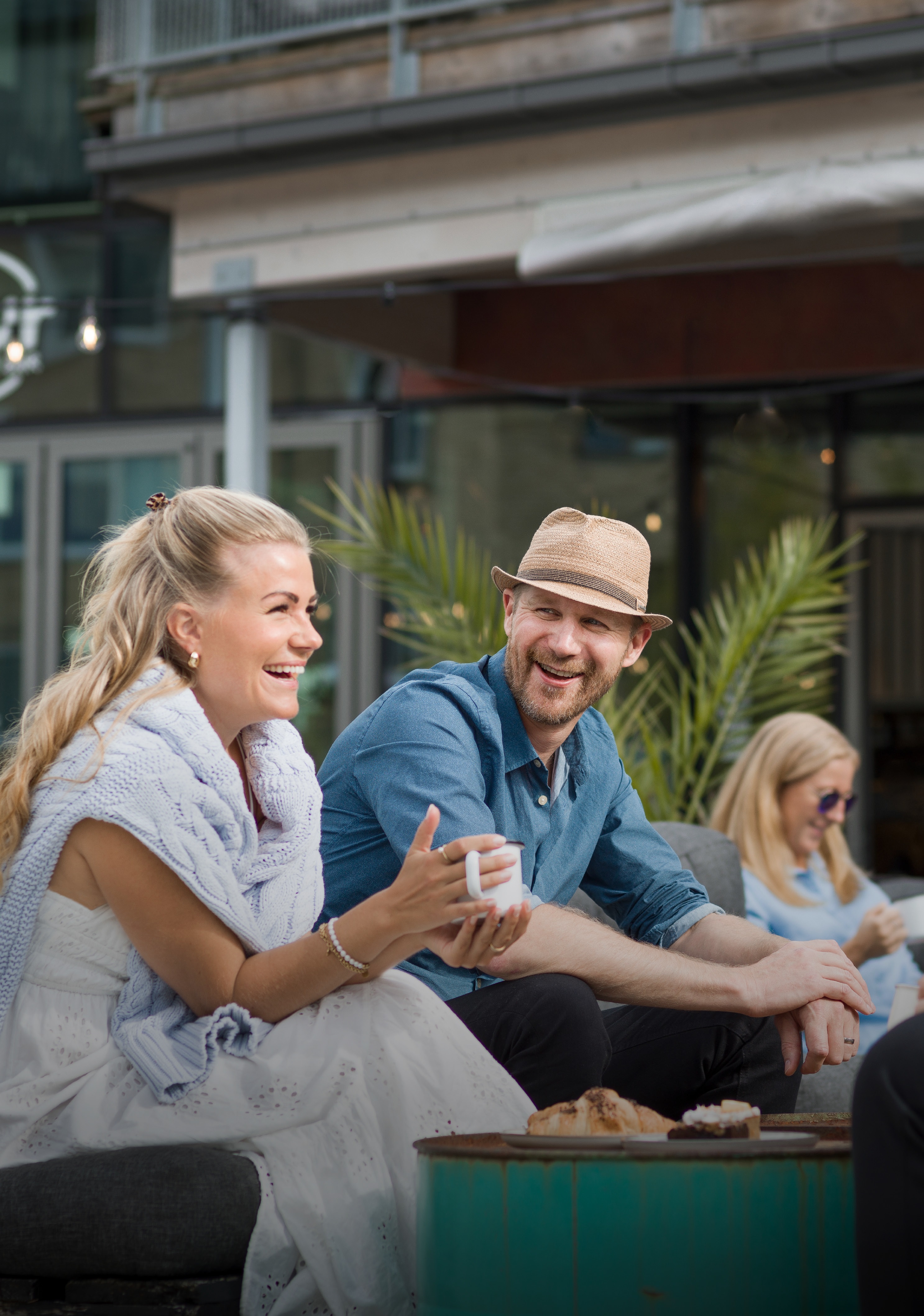 Två personer som sitter utomhus vid ett bord och fikar