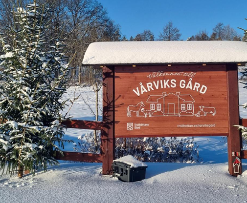 Skylt för Vårviks Gård med snö runtomkring